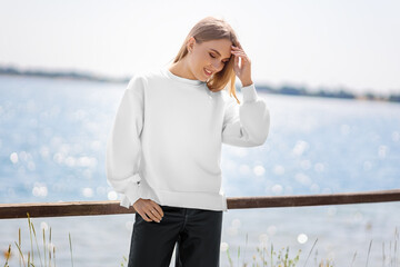 Mockup of white sweatshirt on blonde girl on background of river, quay, pullover front view.