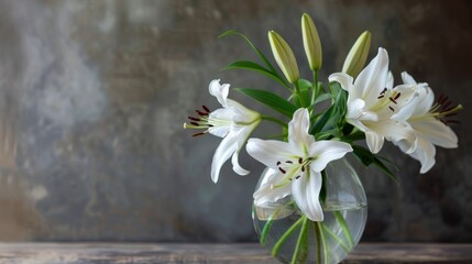 Floral arrangement in glass vase with white lilies