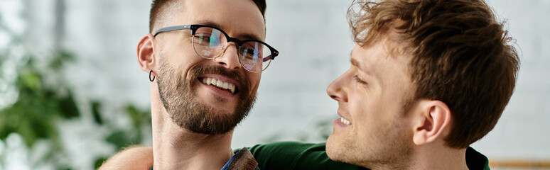 Two men, a gay couple, stand closely united as they work together in a designer workshop creating...