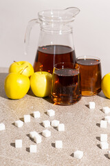 Sugar content in fruit juices. Sugar cubes and glasses of apple juice.