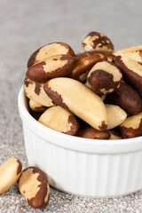 Brazil nuts in plate on grey background
