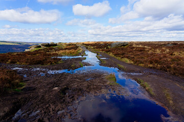 Obraz premium Deep puddles and thick mud across a Peak District path.