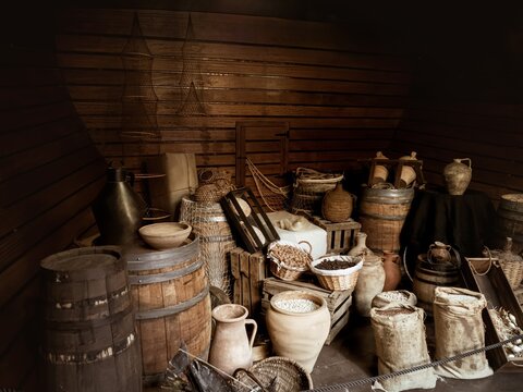 Interior cargo bay area of a wooden historical ship with barrels and ropes, Nao Victoria replica