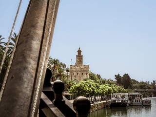 The medieval bastion tower of Seville called Torre del Oro as seen from the historical replica ship...