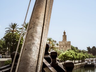 The medieval bastion tower of Seville called Torre del Oro as seen from the historical replica ship...