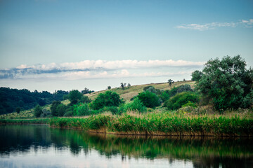 Obraz premium Summer river at morning . Forest on anothe beach. Fog on the water . Green forest . Reflections on the water . Sky over the lake . Trees on beach