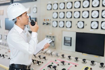 Asian male engineer working on the complex work of a power plant and checking machine circuit...