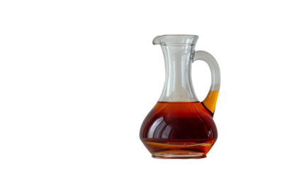 A glass jug filled with liquid rests on a wooden table, its contents reflecting the surrounding light