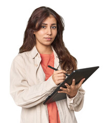 Young Middle Eastern designer with tablet, pencil in studio