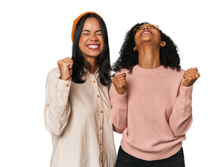 Young Latin friends together in studio celebrating a victory, passion and enthusiasm, happy expression.