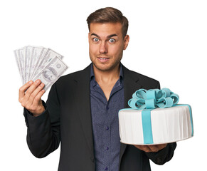 Young man with dollars and cake, merging finance with celebration