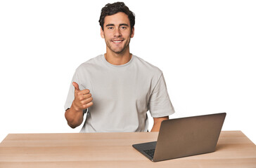 Hispanic young man working on laptop smiling and raising thumb up