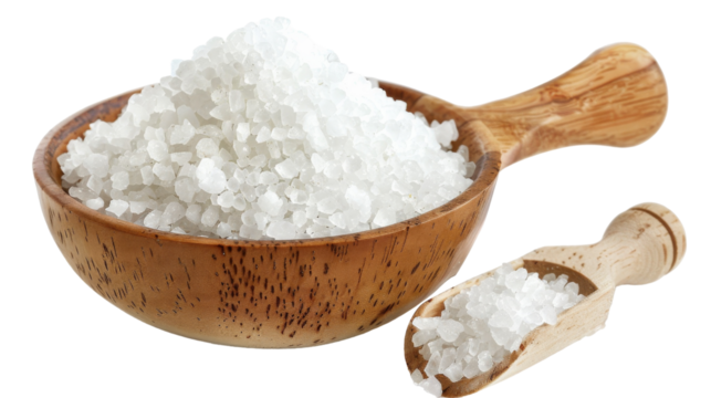 A wooden bowl filled with sea salt sits beside a wooden spoon