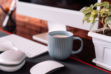 Cozy workplace with wireless devices, houseplant and cup of coffee.