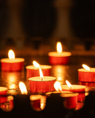 Candles burning in a dark room.