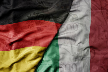big waving realistic national flag of italy and national flag of germany on a euro money banknotes background. finance concept.