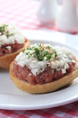 mettbrötchen with onions on wooden table