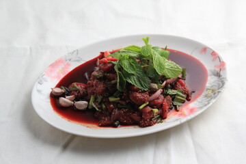 Thai food, Northeastern food, Larb Koi salad, raw beef salad. Northeastern Thai food. Raw meat mixed with spices has a spicy flavor with fresh blood and a bitter taste (called sok lek).