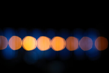 Abstract festive lights background. Bokeh effect in black, gold, yellow, and blue gradient. Close...