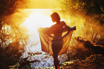 a young woman enjoy sunrise on the water