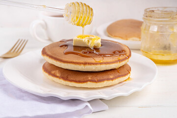 Pancakes with butter and honey or maple syrup drizzles
