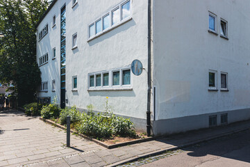 Weiße Fassade eines Reihenhauses in der Ernst-May-Siedlung Frankfurt mit bepflanztem Vorgarten