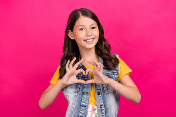 Photo of positive girl kid make heart gesture isolated bright color background