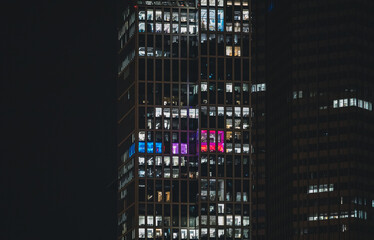 Bunte Lichtakzente in der nächtlichen Bürofassade