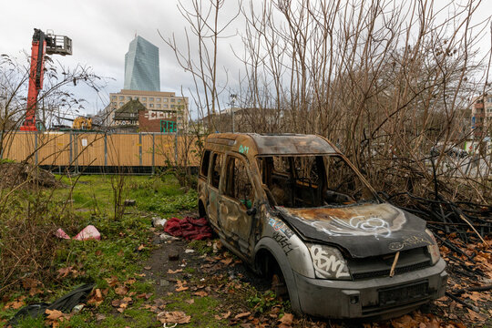 Verbranntes Auto auf verwilderter Baustelle mit Blick auf die EZB in Frankfurt