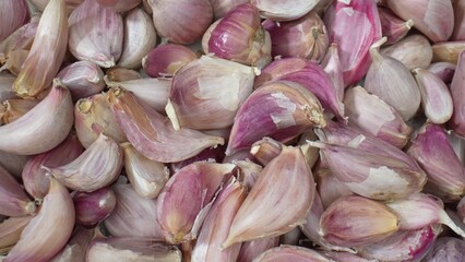 This macro showcases the intricate textures and vibrant colors of garlic cloves up close, revealing their unique patterns and natural beauty. 
