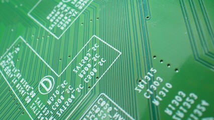 A close-up macro reveals intricate patterns of a Printed Circuit Board (PCB). Tiny solder joints...
