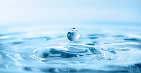 macro drop falling onto the surface of clear water, leaving circles behind