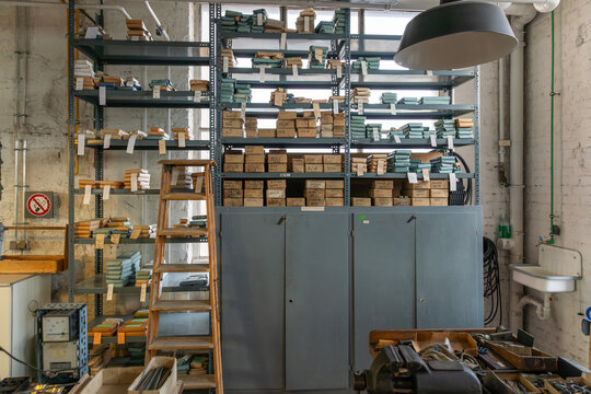 Blick in ein historisches Ersatzteillager oder eine alte Werkstatt mit hohen Metallregalen und einer h&ouml;lzernen Trittleiter