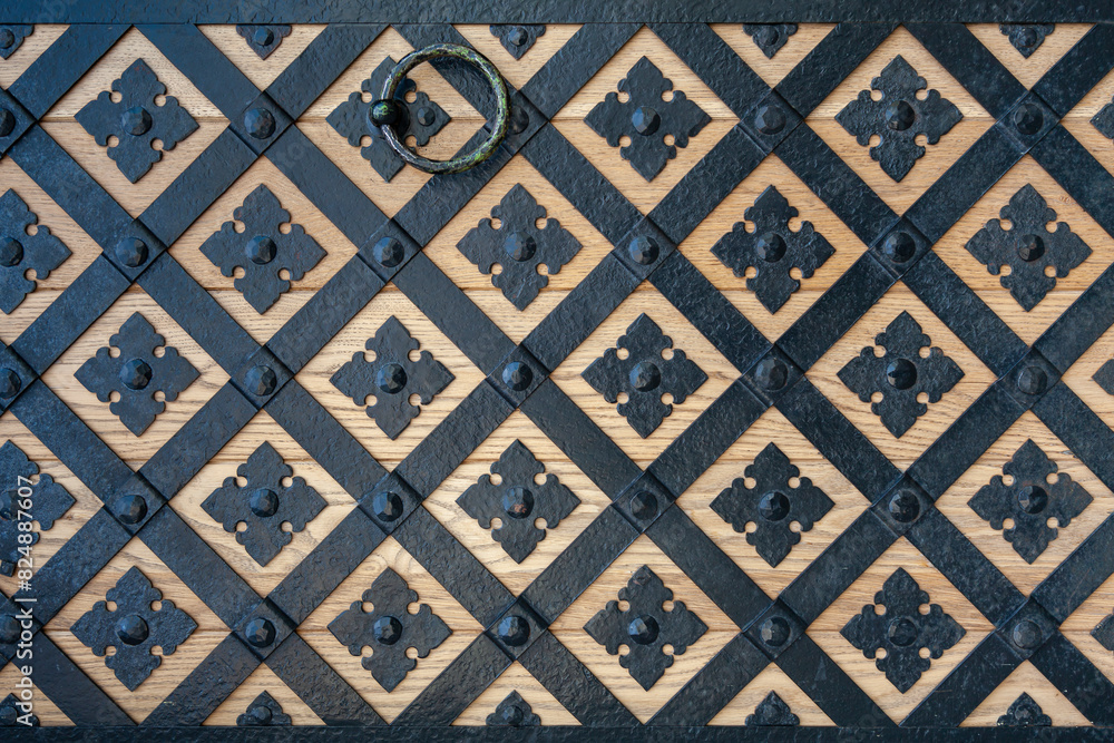Poster background image - a fragment of a wooden gate covered with a wrought iron pattern