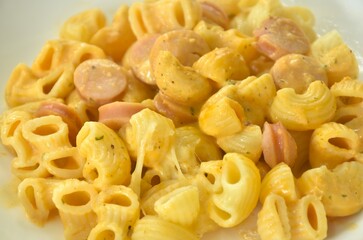 baking macaroni and slice pork sausage with chees on plate