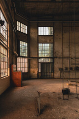 Verstaubte Fensterfront mit hohen Industrieglasflächen in leerem Maschinenraum