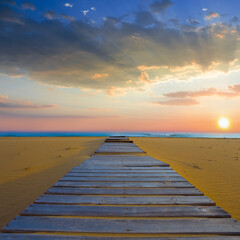 Obraz premium sandy sea beach with wooden street at the sunset
