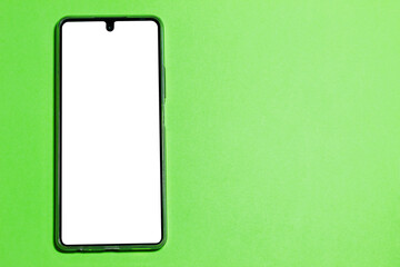 Cell phone with blank screen on a green background. Image with copy space.