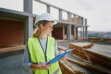 Fototapeta premium Female blonde lady woman engineer smiling at construction site