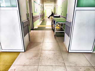 Sunlit Hospital Corridor With Gurney And Person Walking, Midday