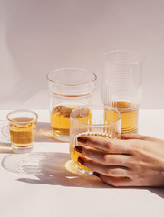 Glasses of whiskey with ice cubes on a white background in the sun's light. Drink art concept.