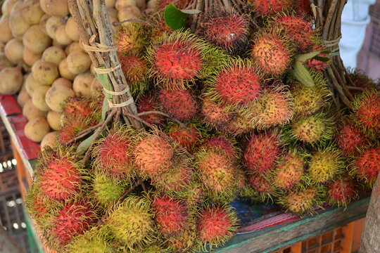 Fresh rambutans is known of "Rambutan Gula Batu" on wooden table. Organic raw rambutans with leaf is a tropical fruit, sweet taste. Fully red rambutans sell at Thai farms market ready to eat.