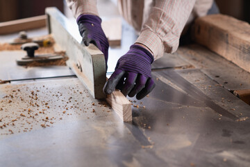 Carpenter woodworking, using thickness planer machine in carpentry workshop, wearing safety...