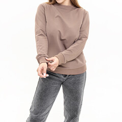 Attractive woman in brown long sleeve shirt. Cotton sweatshirt and jeans on white background