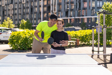 Happy man with his daughter playing ping pong in park