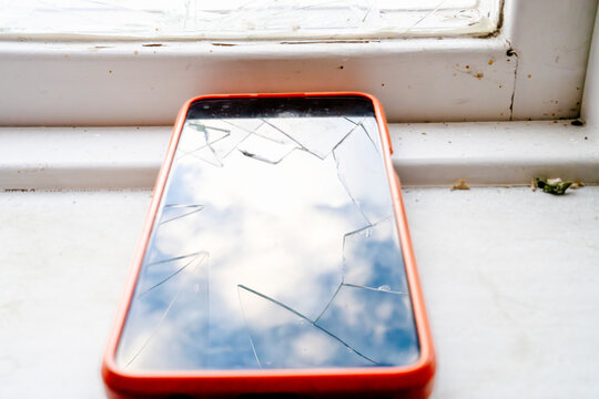 Close-up of broken touchscreen of smart phone on window sill