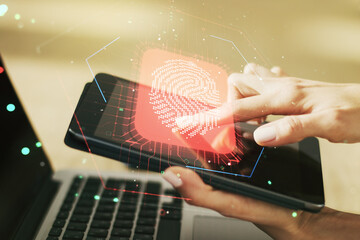 Multi exposure of abstract fingerprint scan interface and hand working with a digital tablet on background, digital access concept