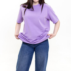 Woman in cotton long lilac T-shirt and blue jeans on white background. Square