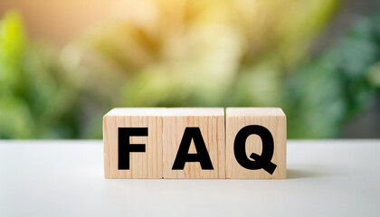 Wooden blocks spelling "FAQ" on a desk symbolize frequently asked questions. The blocks are neatly arranged, suggesting organization and clarity in addressing common inquiries