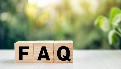 Wooden blocks spelling "FAQ" on a desk symbolize frequently asked questions. The blocks are neatly arranged, suggesting organization and clarity in addressing common inquiries